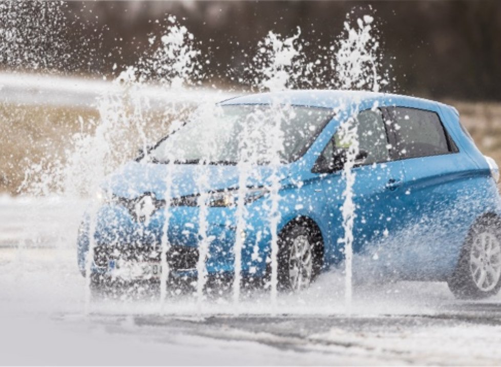 Blaues E-Auto beim Aquaplaning-Training
